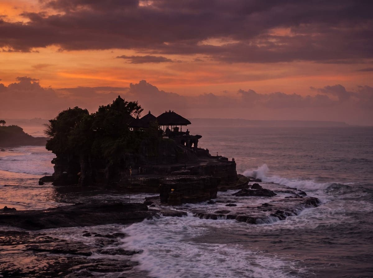 Sea temple on a rock formation off the Bali coast at sunset